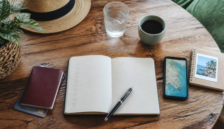 Checklist voor het kiezen en vergelijken van vakanties op een houten tafel met paspoort en notitieboek